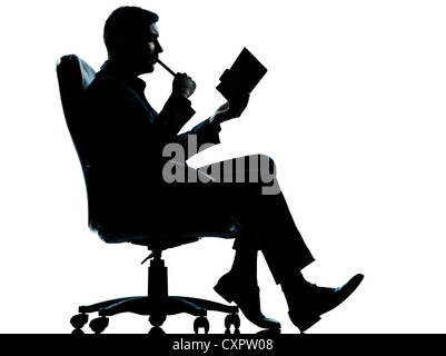 Un caucasian business man sitting in armchair silhouette pleine longueur en studio isolé sur fond blanc Banque D'Images