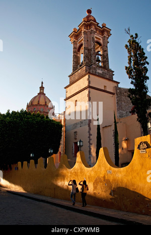 Piétons sur San Miguel de Allende's Canal Street en fin d'après-midi passant Templo de la Concepcion Banque D'Images