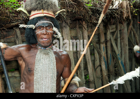 Un guerrier chasseur d'une tribu papoue Dugum Dani en vêtements traditionnels et de coloration Banque D'Images