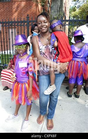 USA : Brooklyn, New York. Mère et ses deux enfants attendent en costume, à mars dans les Caraïbes Kiddies Day Parade, 2012. Banque D'Images