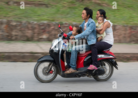 Une jeune famille passent sur leur scooter à Luang Prabang, Laos Banque D'Images