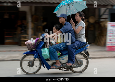 Une passe familiale par sur leur moto dans Luang Prabang, Laos Banque D'Images