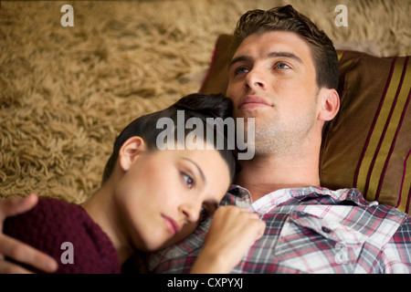 Jeune couple lying on floor Banque D'Images