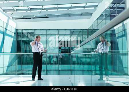 Doctor holding medical records in hospital corridor Banque D'Images