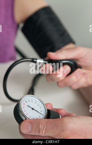 Médecin à l'aide de la jauge de pression sur le patient pendant l'examen médical Banque D'Images