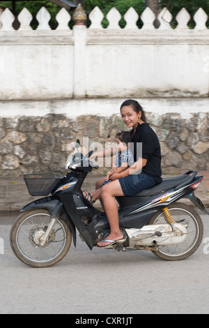 Une ambiance jeune mère et sa fille passent sur leur mororbike à Luang Prabang, Laos. Banque D'Images