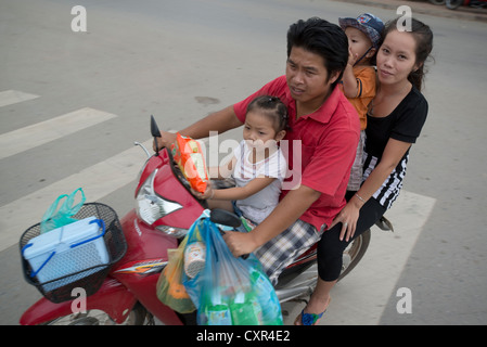 Une jeune famille passent sur leur moto dans Luang Prabang, Laos Banque D'Images