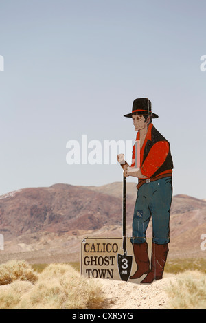 Homme avec une pelle comme un poteau indicateur à l'Calico Ghost Town, Yermo, California, USA Banque D'Images