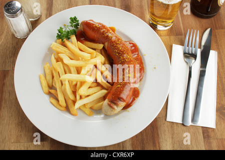 En saucisse sauce au curry avec des frites et de la bière Banque D'Images