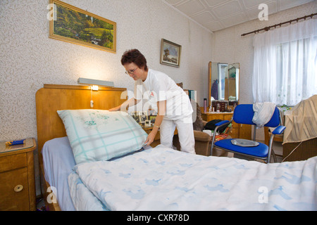 Les soins ambulatoires de l'infirmière de la Croix-Rouge allemande, Anke Lehmann faire le lit pour une attaque cardiaque patient, Treuenbrietzen Banque D'Images