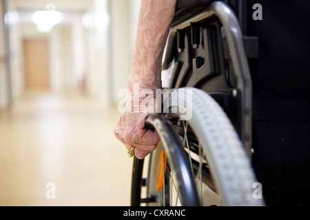 Une femme âgée, vue détaillée de la part du déplacement d'un fauteuil roulant, à une maison de soins infirmiers Banque D'Images