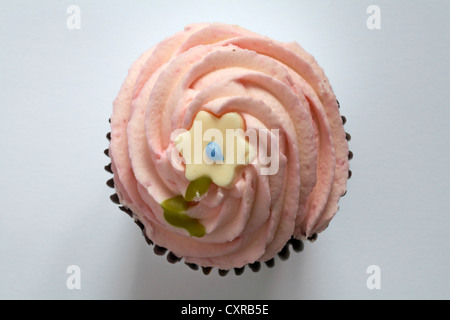 Regardant vers le bas sur fraise cupcake avec daisy au sommet isolé sur fond blanc - d'en haut Banque D'Images