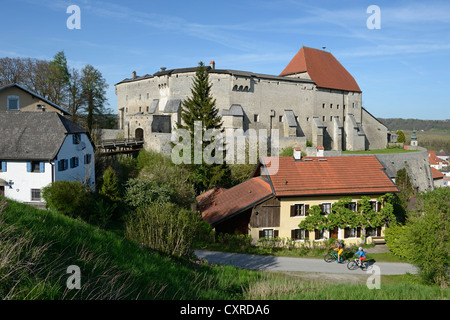 Les cyclistes sur des vélos électriques à l'avant du château de Burg Tittmoning, région de Chiemgau, Upper Bavaria, Bavaria, Germany, Europe Banque D'Images