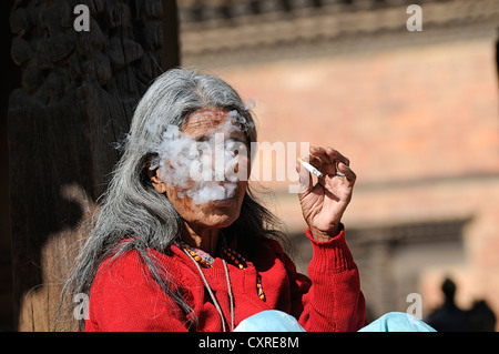 Vieille Femme fumant népalaise, Durbar Square, Bhaktapur, également connu sous le nom de Bhadgaon, Vallée de Kathmandou, Népal, Asie Banque D'Images