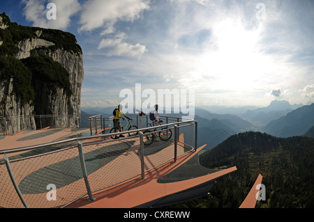 Les cyclistes de montagne debout sur une plate-forme d'observation avec un voir-à travers le plancher, Triassic Park, mountain, Steinplatte Waidring, Tyrol Banque D'Images