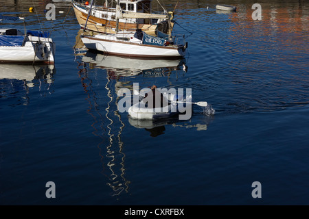 Homme un canot pneumatique d'aviron dans le port le port Seton, East Lothian Banque D'Images