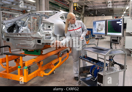 Contrôle de l'employé une Audi points de soudure sur un corps de voiture fixés par des robots avec un capteur, l'usine Audi en Bavière Banque D'Images