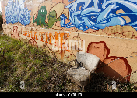 Siesta siège sur une friche industrielle, fauteuil en lambeaux, graffiti wall, ancienne gare de triage, Duisburg-Wedau, Ruhr Banque D'Images