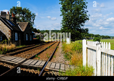 Les lignes de chemin de fer de mener un conseil à condition qu'un passage pour piétons à la courbe autour d'un coude de la distance, Grange-over-Sands Banque D'Images