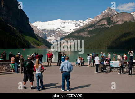De nombreux touristes sont attirés par cet affichage classique de Lake Louise dans le parc national de Banff. Banque D'Images