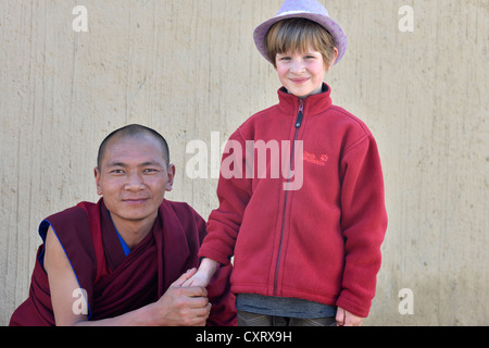 Moine tenant la main d'un enfant européen, 6 ans, le monastère de Labrang, Xiahe, Gansu, anciennement l'Amdo, Tibet, Chine, Asie Banque D'Images