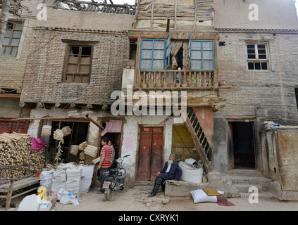 Ancien musulman avec une barbe et deux jeunes travailleurs du bois dans une vieille maison de terre séchée et les Ouigours, artisan street, Kashgar Banque D'Images