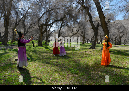 La minorité chinoise le tourisme, les touristes chinois à partir d'un groupe mettent sur le costume traditionnel de la minorité kazakhe