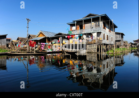 Des maisons sur pilotis avec des réflexions sur le lac Inle, en Birmanie aussi connu sous le nom de Myanmar, en Asie du Sud-Est, l'Asie Banque D'Images