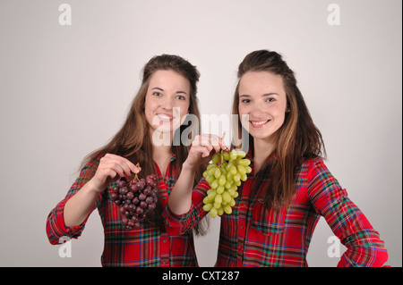 Twin Sisters holding grapes Banque D'Images