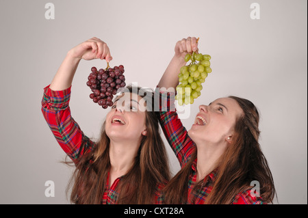 Twin Sisters holding grapes Banque D'Images