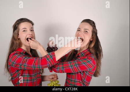 Twin Sisters holding grapes Banque D'Images