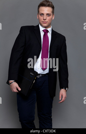Jeune homme en costume et cravate avec un ordinateur portable Banque D'Images