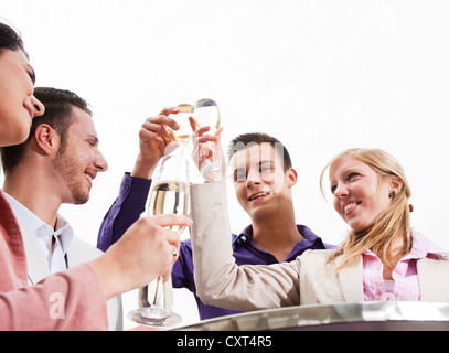 Un groupe de jeunes gens boucher verres, célébrer Banque D'Images