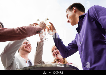 Un groupe de jeunes gens boucher verres, célébrer Banque D'Images