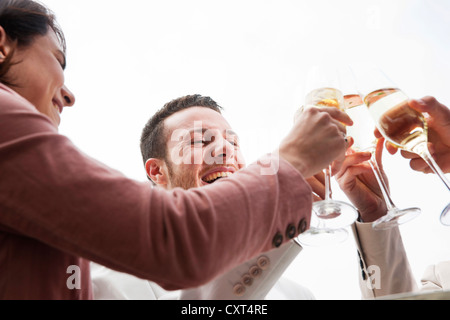 Un groupe de jeunes gens boucher verres, célébrer Banque D'Images