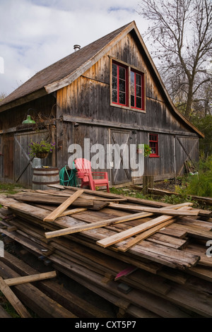 Ancienne grange en bois dans un jardin résidentiel en automne, Québec, Canada Banque D'Images