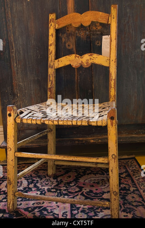 Chaise en bois ancien et armoire à l'intérieur d'une vieille maison et magasin d'antiquités, Lanaudière, Québec, Canada. Cette image est Banque D'Images