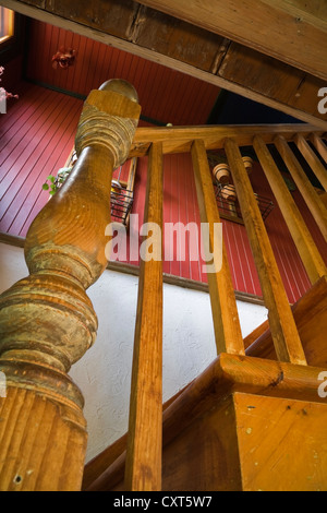 Gros plan de l'ensemble de balustres et balustrades dans un vieux escalier en bois dans une ancienne résidence de style cottage Canadiana log home, vers Banque D'Images