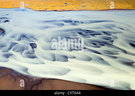 Vue aérienne de l'écoulement de l'eau glaciaire laiteux et les modèles de structures sur la rivière Holsa près de Selfoss, juste avant l'estuaire Banque D'Images