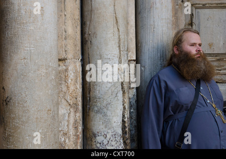 Prêtre orthodoxe russe debout à côté de colonnes à l'entrée du Saint-Sépulcre. Vieille ville de Jérusalem. Israël. Banque D'Images