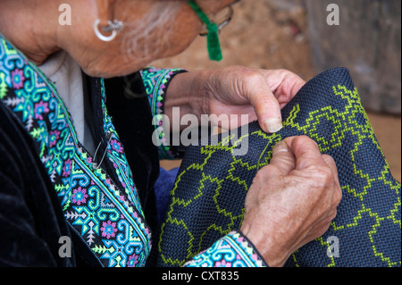 Personnes âgées, traditionnellement vêtus femme de la tribu Hmong noir hill, minorité ethnique de l'Asie de l'Est, faire la couture Banque D'Images