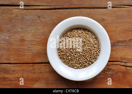Les grains de sarrasin en blanc bol sur table en bois vintage background Banque D'Images