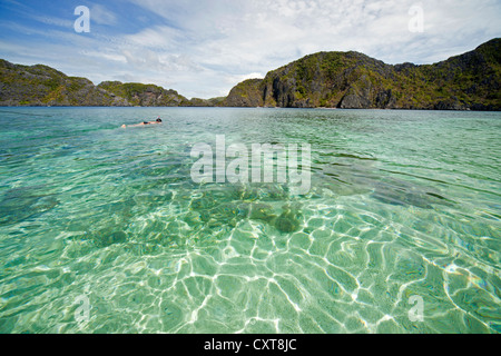 Snorkeler dans les eaux claires de l'Île Tapiutan, Bacuit archipelago, El Nido, Palawan, Philippines, Asie Banque D'Images