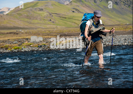 Female hiker pataugeant par Bláfjallakvísl la rivière glaciaire, sur le sentier de randonnée Laugavegur, Álftavatn-Emstrur Banque D'Images