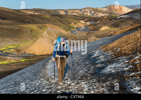 Female hiker marche sur un champ de neige, rhyolite montagne couverte de cendres et de neige sur le sentier de randonnée Laugavegur Banque D'Images