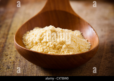 La farine de maïs dans une cuillère en bois Banque D'Images