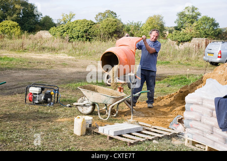 Workman sur chantier à l'aide de Bétonnière Banque D'Images