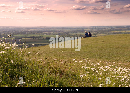 - Bucks - Chiltern Hills sur Whiteleaf Hill - la fin de l'après-midi la lumière - couple assis sur le gazon - profiter de la vue Banque D'Images