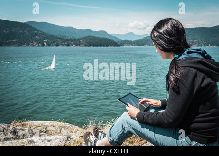 Woman using tablet computer outdoors Banque D'Images