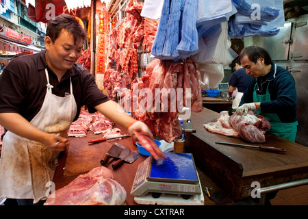 Les bouchers dans le Marché Central de Hong Kong, préparer des coupes de viande pendant une période creuse à leur boucherie. Banque D'Images